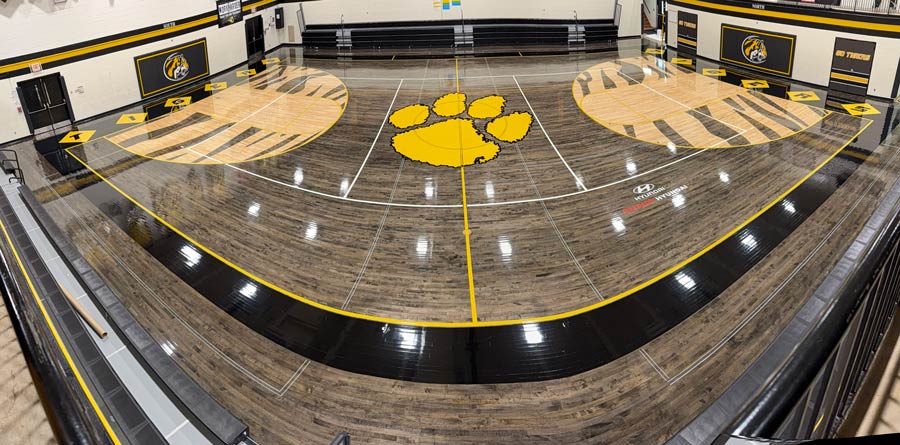 High school gymnasium with a wooden basketball court High school gymnasium with a wooden basketball court